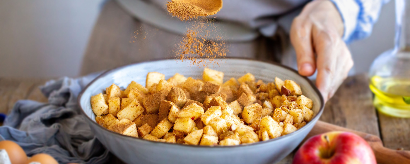 Decorative Chopped up apples being coated in cinnamon for the apple crisp.